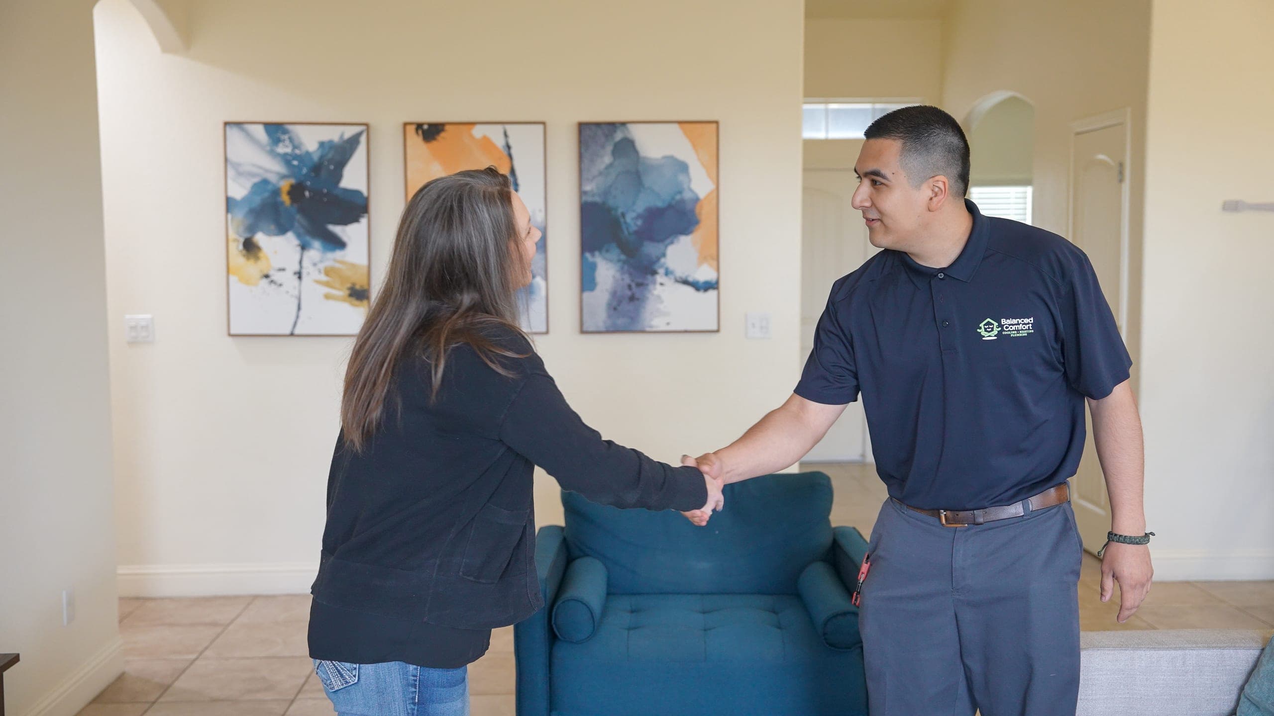 A Balanced Comfort technician shaking hands with a satisfied homeowner